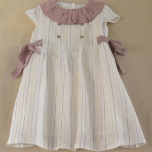 Vestido infantil de rayas crudo con cuello rosa y lazos a los lados.